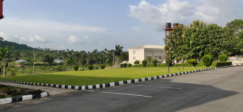 Green lawn and hotel building with forested hills beyond
