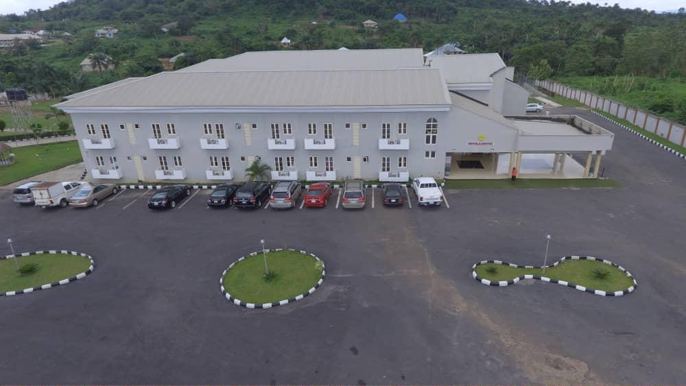 Aerial view of Upper Spring Hotel with parking and green hills beyond